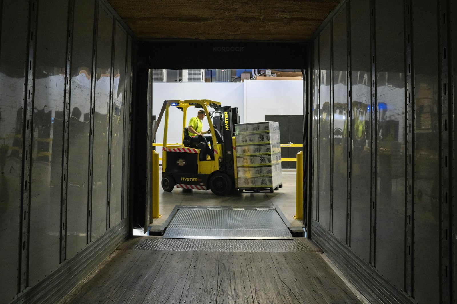 Forklift loading pallets into a trailer at a dock
