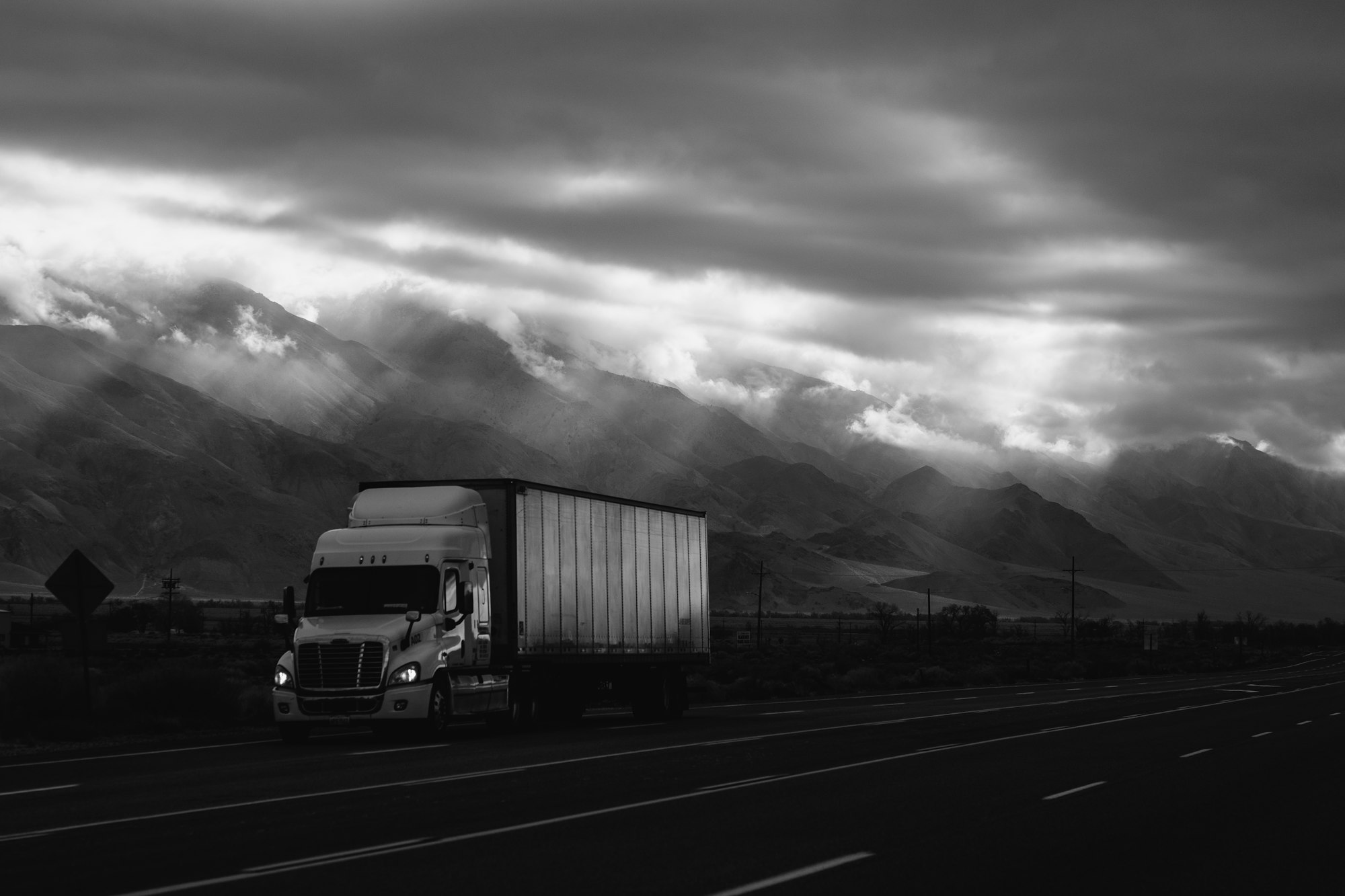 Semi truck on a mountain highway, black and white