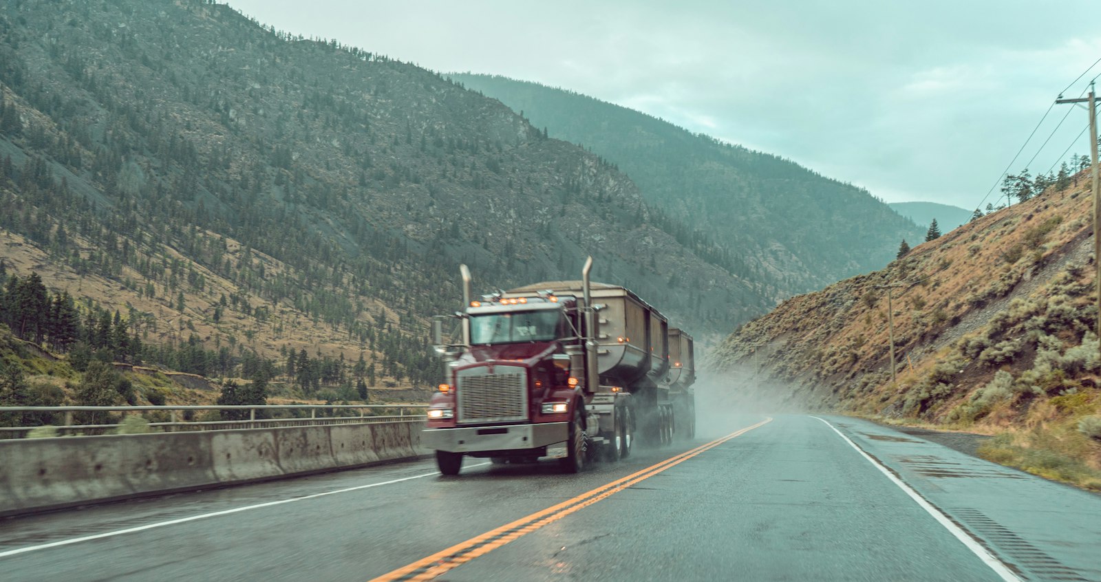 Semi truck driving a mountain highway in the rain